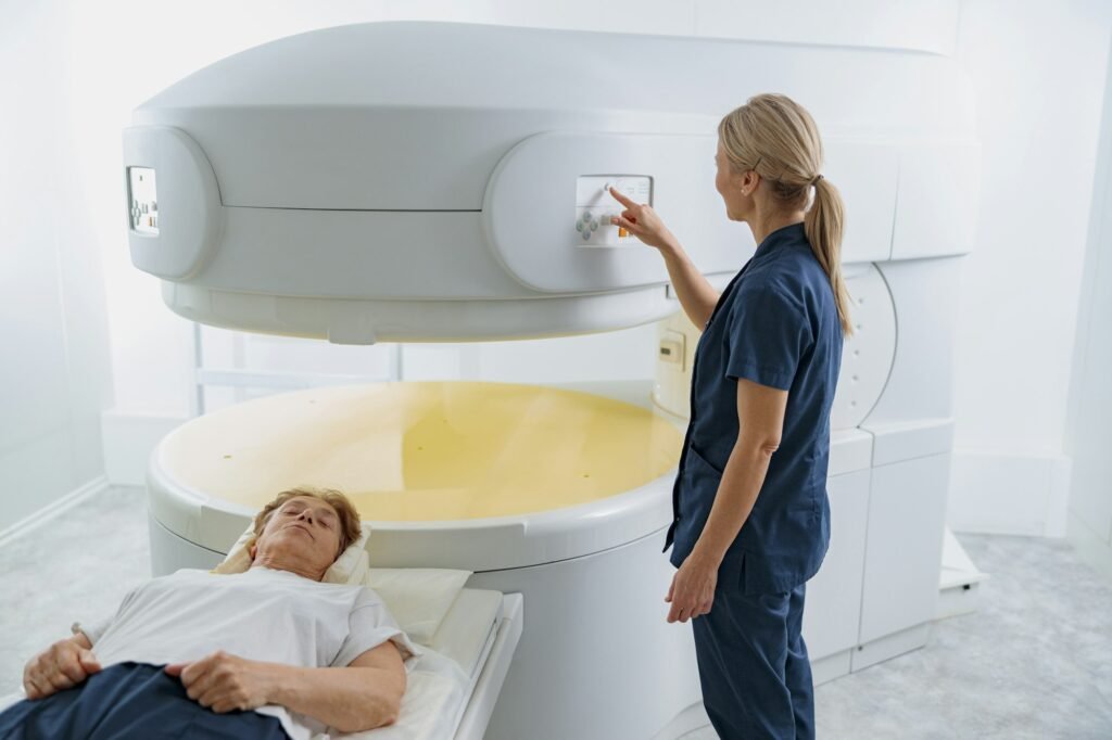 Radiologist controls MRI or CT or PET Scan with female patient undergoing procedure